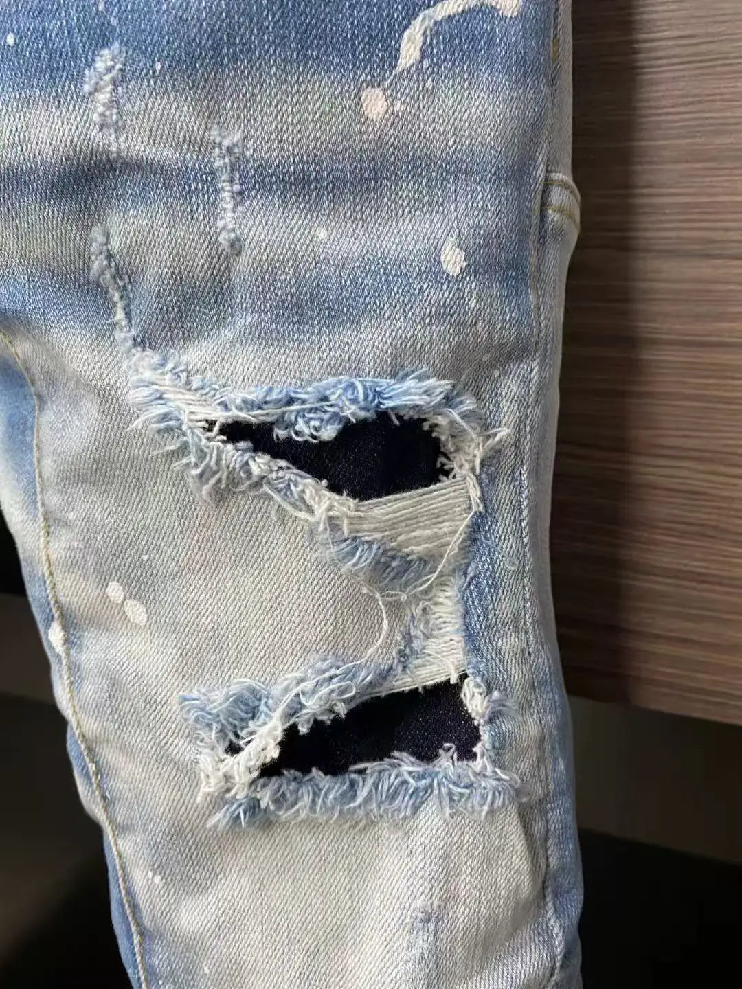 Trendy street style large ripped paint-splatter jeans for men,